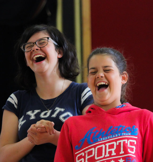 Children sharing a joyful moment of laughter at a camp event