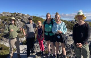 Campers smiling on top of a mountain